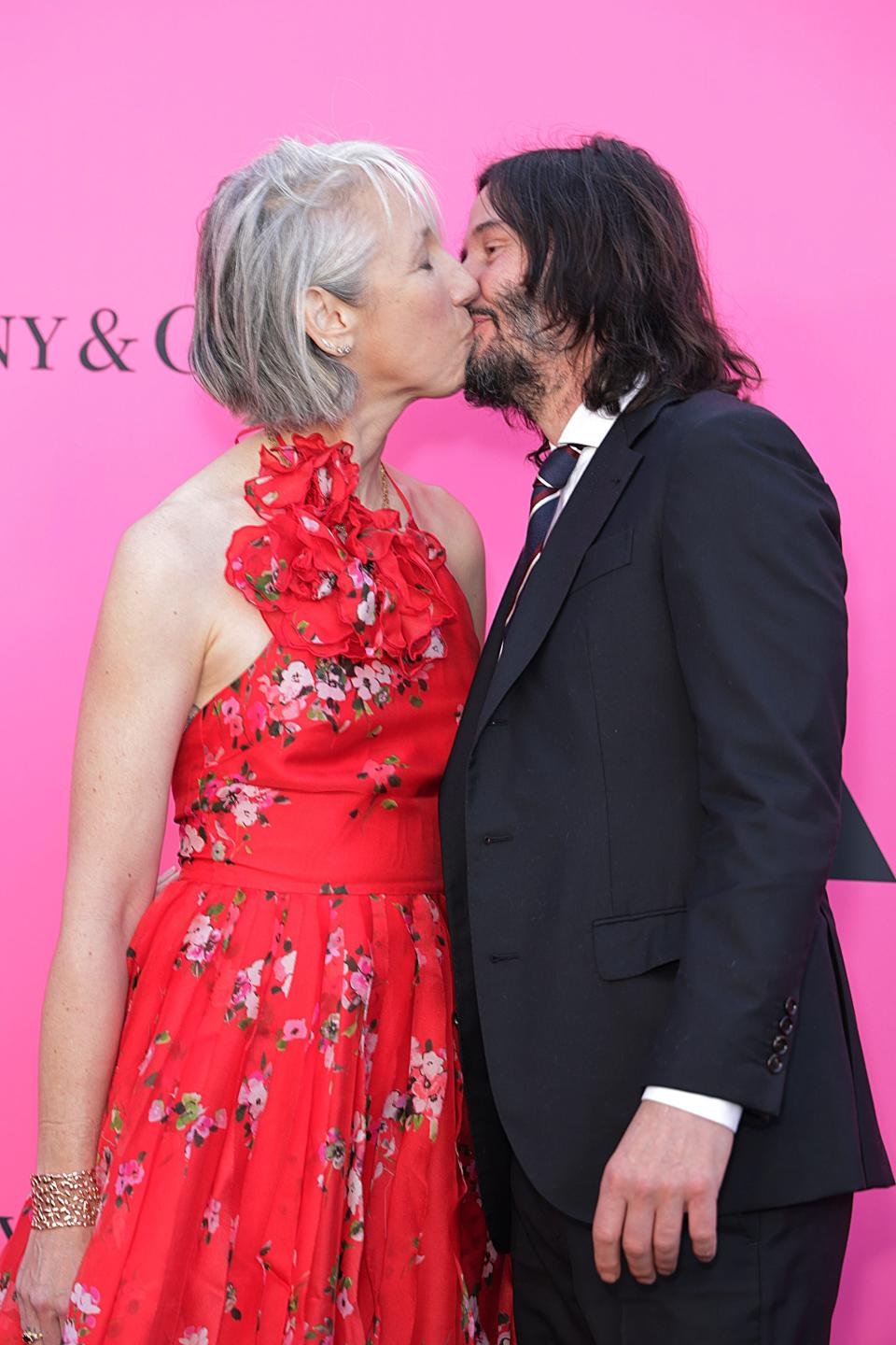 Keanu Reeves and his girlfriend, Alexandra Grant, share a kiss in a