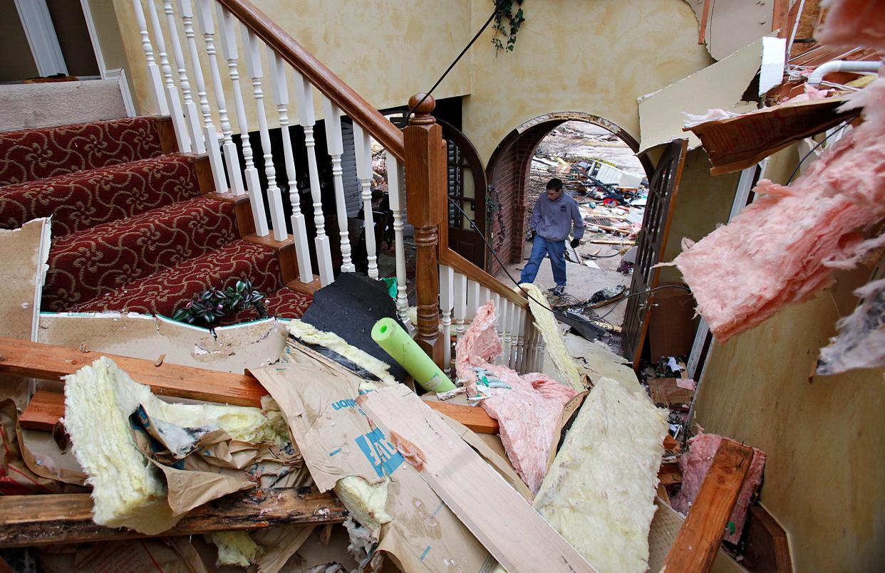 Residents of Edmond's Oak Tree neighborhood clean up after damage to a home by a tornado.