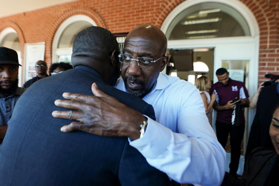 Georgia's Democratic Senate nominee Sen. Raphael Warnock embraces a supporter during a campaign stop on the campus of Morehouse College on Tuesday, Nov. 8, 2022, in Atlanta.