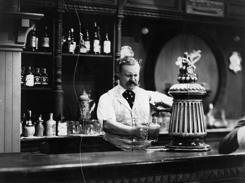 <p>This bartender's also looking suave filling up a beer mug for someone. Apparently, the original caption written on the back of this photo's print was "Sins of the Father," so did a bitter son take this shot?</p>