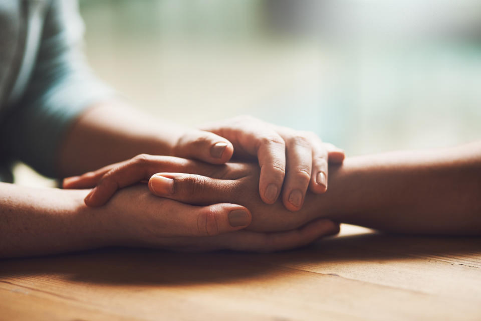 Shot of two people holding hands in comfort. Research shows many cases of wanted abortions do not cause a decline in mental health, but restriction to access does.