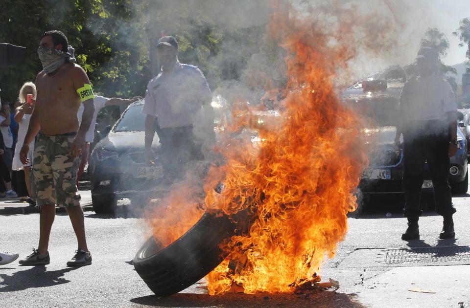 Taxi drivers on strike burn tyres during a national protest against car-sharing service Uber in Marseille, France, June 25, 2015. (REUTERS/Jean-Paul Pelissier)