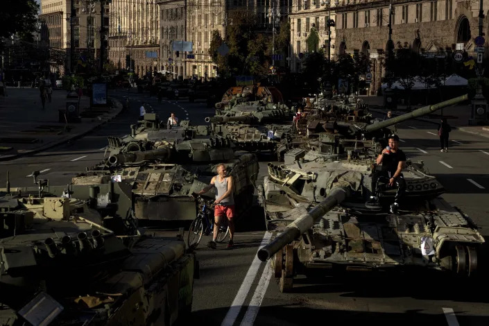 Mọi người đi bộ xung quanh các phương tiện quân sự bị phá hủy của Nga được lắp đặt ở trung tâm thành phố Kyiv, Ukraine, Thứ Tư, ngày 24 tháng 8 năm 2022. (Ảnh AP / Evgeniy Maloletka)