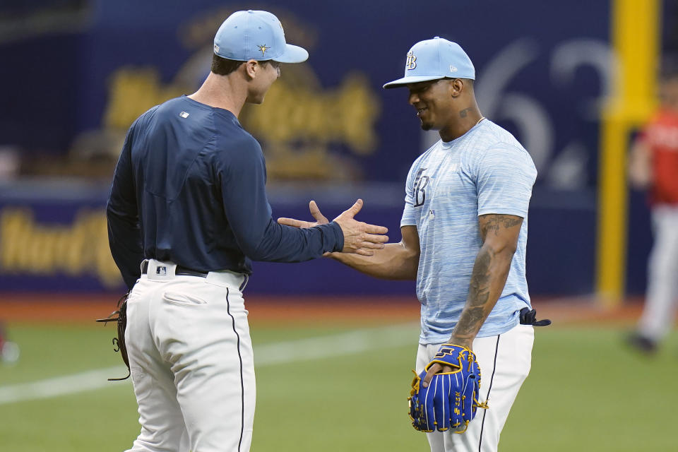 Tampa Bay Rays third baseman Wander Franco, right, shakes hands with fellow third baseman Joey Wendle before a baseball game against the Boston Red Sox Tuesday, June 22, 2021, in St. Petersburg, Fla. The Rays called Franco up from their Class AAA Durham team. (AP Photo/Chris O'Meara)