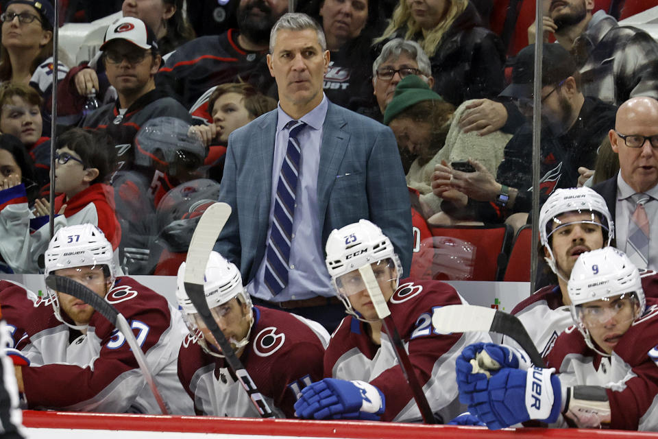 Colorado Avalanche head coach Jared Bednar, top center, watches from behind the bench during the third period of an NHL hockey game against the Carolina Hurricanes in Raleigh, N.C., Thursday, Nov. 17, 2022. (AP Photo/Karl B DeBlaker)