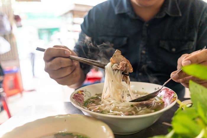 someone eating pho in a vietnamese restaurant