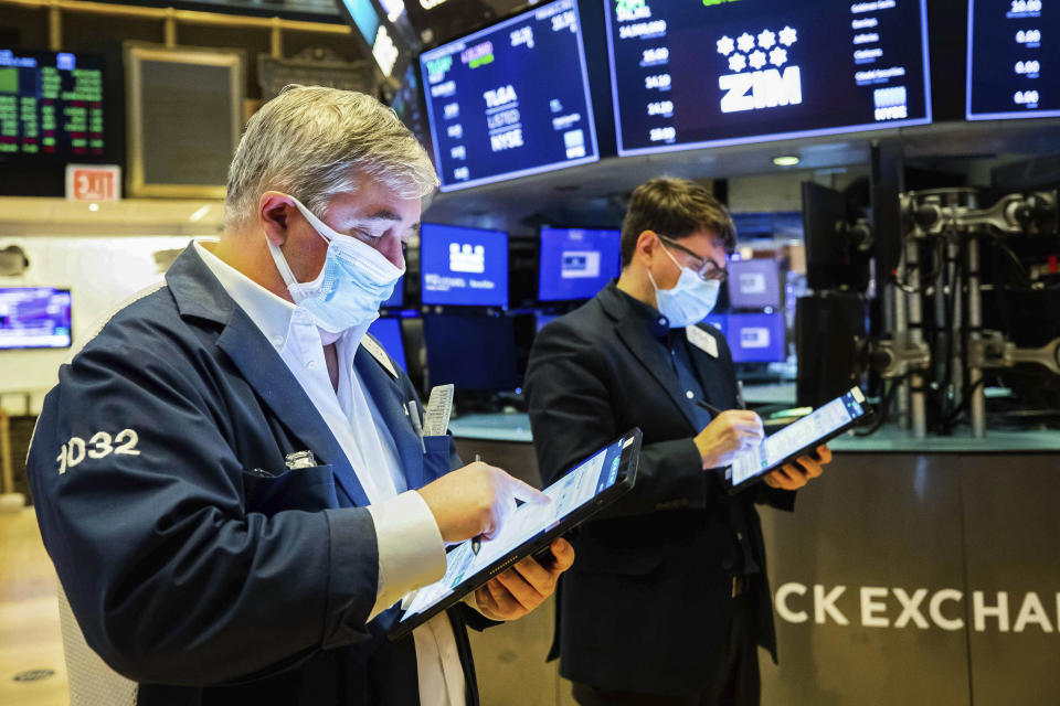 In this photo provided by the New York Stock Exchange, a pair of traders work on the floor, Tuesday Feb. 2, 2021. Stocks were broadly higher in afternoon trading Tuesday, but shares of closely watched companies like GameStop and AMC Entertainment were falling sharply. (Colin Ziemer/New York Stock Exchange via AP)