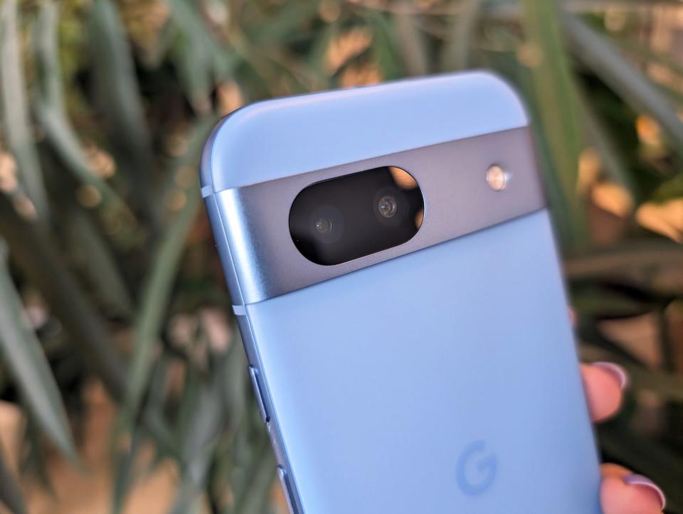 Google Pixel 8a held in hand with purple nails