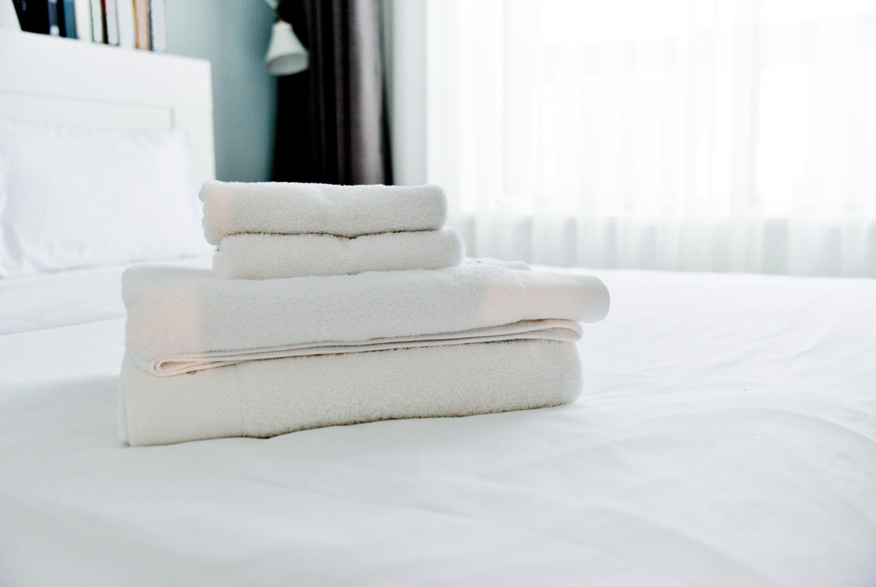 Clean towels on hotel bed.