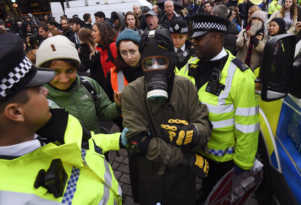 Police arrest a climate activist during an Extinction Rebellion protest in London, Monday, Oct. 7, 2019. London Police say some 135 climate activists have been arrested as the Extinction Rebellion group attempts to draw attention to global warming. Demonstrators playing steel drums marched through central London on Monday as they kicked off two weeks of activities designed to disrupt the city. (AP Photo/Alberto Pezzali)
