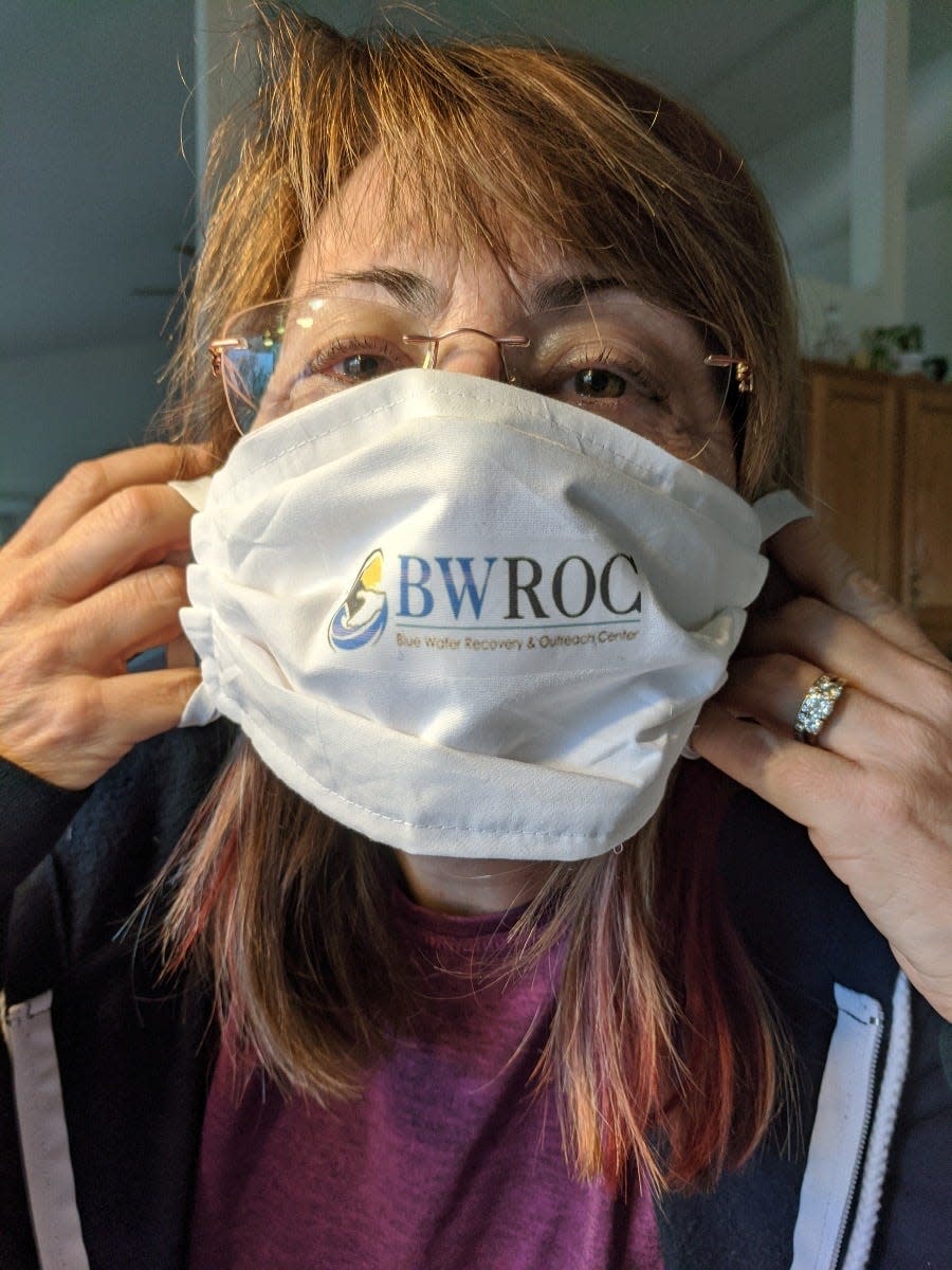 A Sacred Heart Rehabilitation Center employee wears a mask made by Blue Water Recovery and Outreach Center.