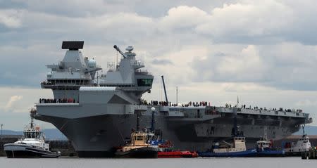 The British aircraft carrier HMS Queen Elizabeth is pulled from its berth by tugs before its maiden voyage, in Rosyth, Scotland, Britain June 26, 2017. REUTERS/Russell Cheyne