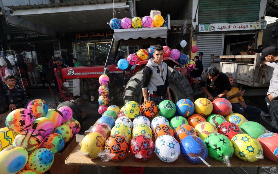 A Palestinian vendor sells balls at a market in Rafah refugee camp in the Gaza Strip