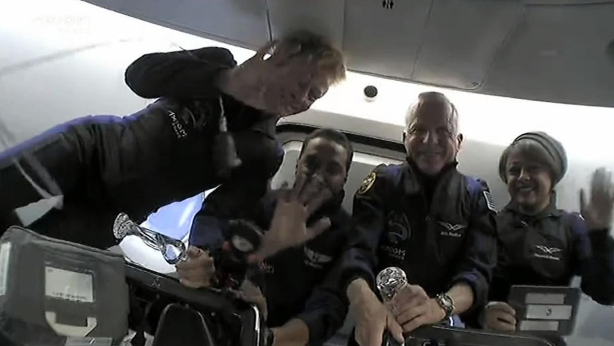  astronauts floating inside a SpaceX Crew Dragon capsule 