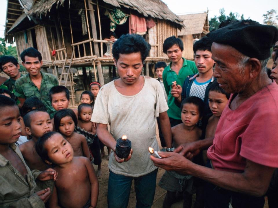 Villagers show off a cluster bomb in Laos.