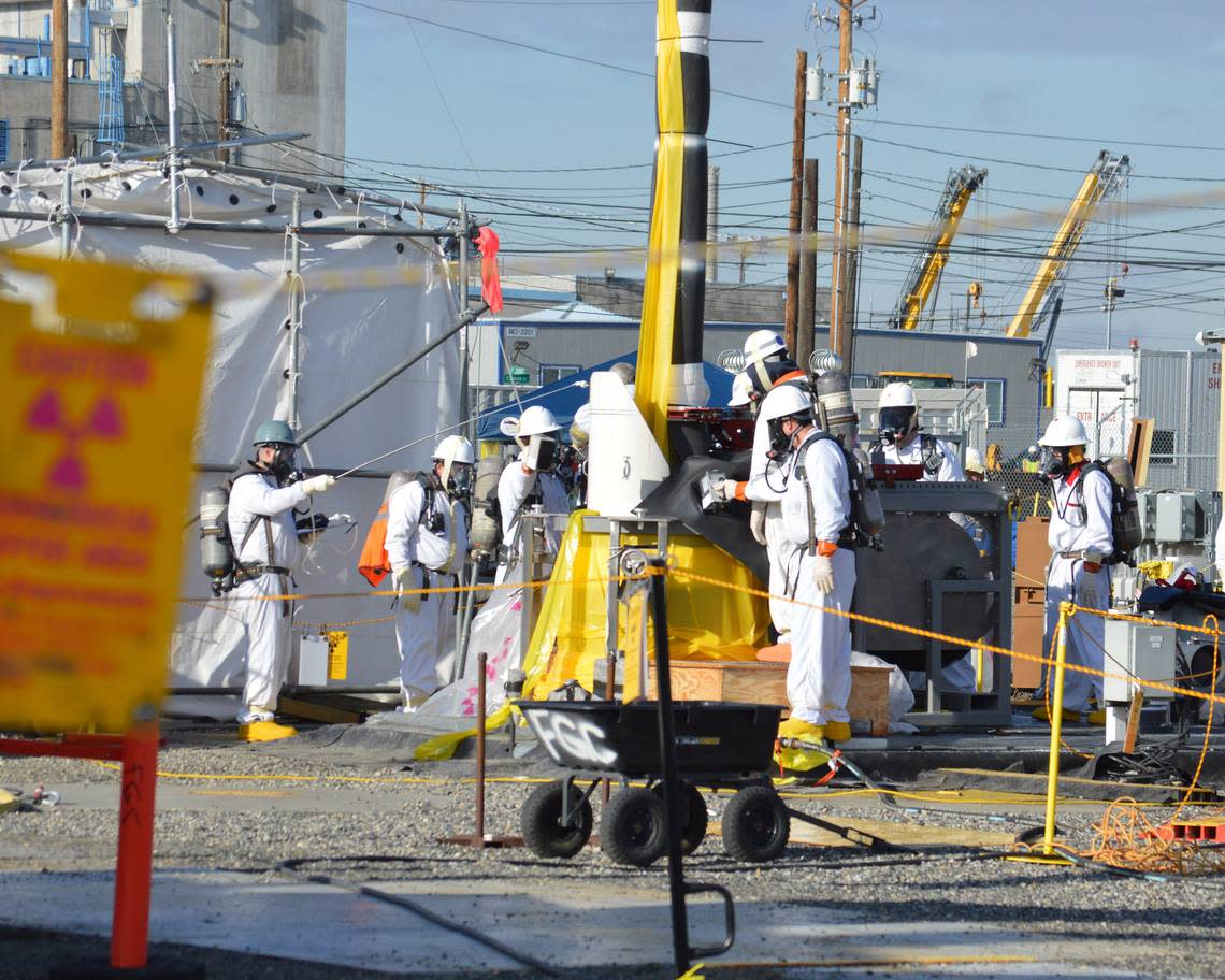 Workers are shown at one of the Hanford tank farms where 56 million gallons of radioactive waste are stored in underground tanks.