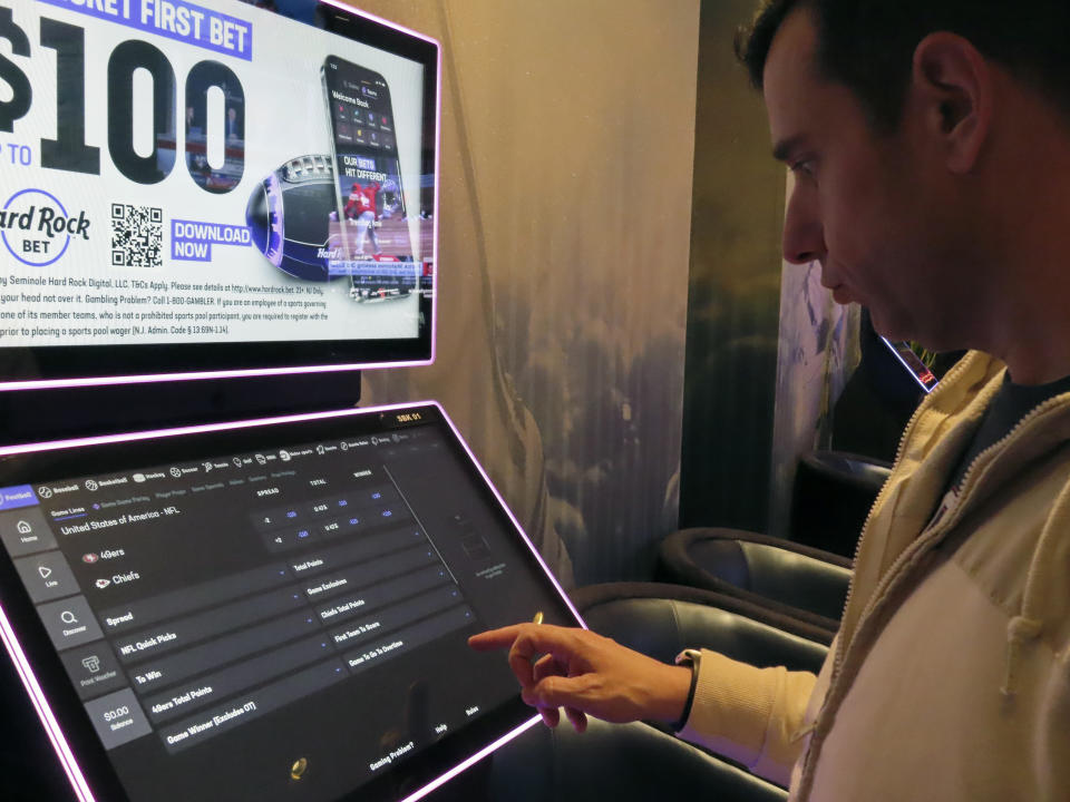 Matt Smircich, of Hamburg, N.J., makes sports bets at the Hard Rock casino in Atlantic City, N.J., Friday, Feb. 2, 2024. On Tuesday, Feb. 6, 2024, the American Gaming Association estimated that a record 68 million Americans would wager a total of $23.1 billion on this year's Super Bowl, legally or otherwise. (AP Photo/Wayne Parry)