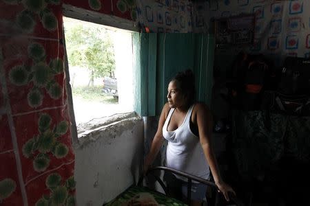 A woman, who is planning to migrate illegally to the U.S., poses for a picture at her home in the small village of Suyatal, outskirts of Tegucigalpa June 25, 2014. REUTERS/Jorge Cabrera