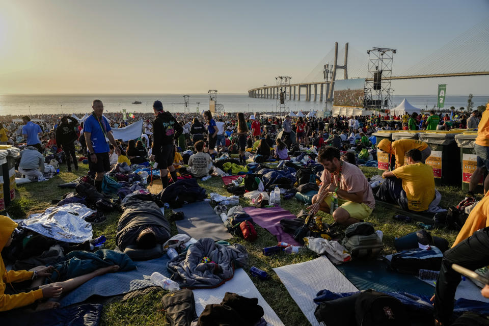 Pilgrims wake up after sleeping at the Parque Tejo in Lisbon where Pope Francis will preside over a mass celebrating the 37th World Youth Day, Sunday, Aug. 6, 2023. An estimated 1.5 million young people filled the parque on Saturday for Pope Francis' World Youth Day vigil, braving scorching heat to secure a spot for the evening prayer and to camp out overnight for his final farewell Mass on Sunday morning. (AP Photo/Gregorio Borgia)