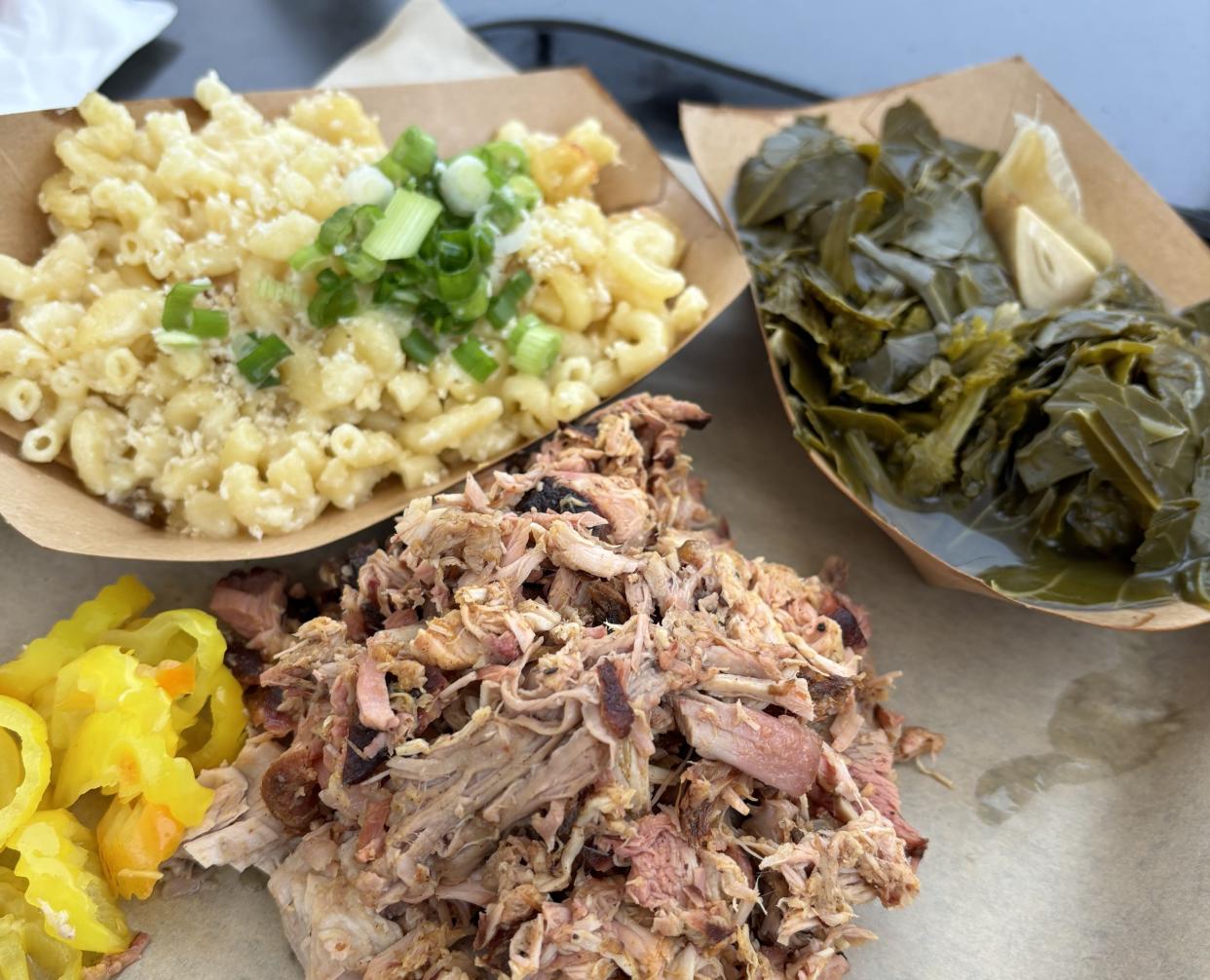 A plate of pork barbecue with mac and cheese and greens from Circle Pit BBQ at the Concept Kitchen Co.
