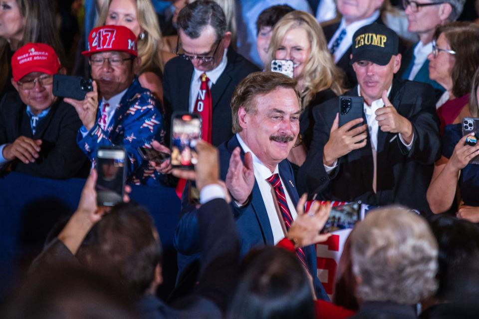 Michael Lindell, founder and CEO of My Pillow, waves to guests while arriving at Mar-A-Lago on Tuesday, April 4, 2023.