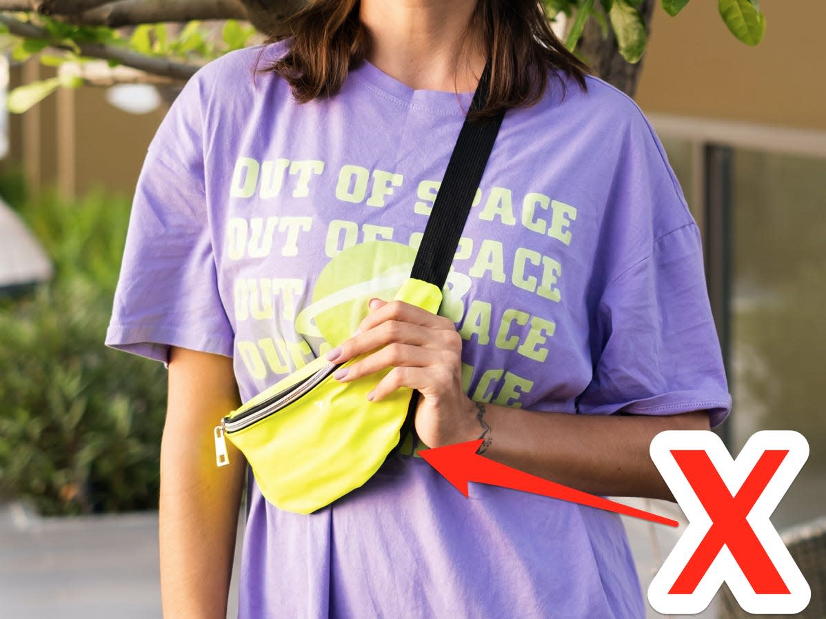 Girl wearing a purple tshirt and a yellow cross-body fanny pack with red X pointed at it
