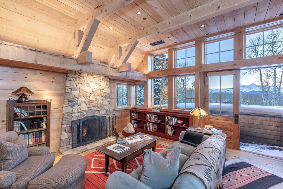 Rustic wood walls and stone fireplaces create a cozy vibe.