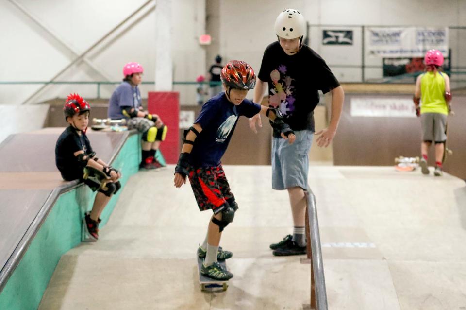 Henry Foots 11, of Sterling Heights, gets back at it with help from instructor Parker Shay during the skate clinic held at Modern Skate Park on Monday, July 10, 2023. 