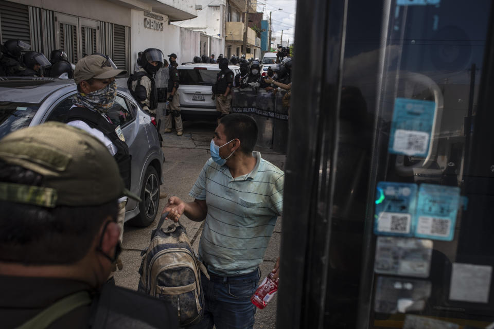 A detained migrant boards a bus at the Attorney Generals office after his group was intercepted from inside cargo trailer trucks driving on the highway, in Coatzacoalcos, Veracruz state, Mexico, Friday, Nov. 19, 2021. About 500 migrants were riding in two cargo trucks when they were stopped and detained by the Criminal Investigation Agency and the National Immigration Institute, according to those two organizations. (AP Photo/Felix Marquez)