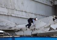 DORAL, FL - OCTOBER 10: A Miami-Dade Fire Rescue search and rescue worker searches in the rubble of a four-story parking garage that was under construction and collapsed at the Miami Dade College’s West Campus on October 10, 2012 in Doral, Florida. Early reports indicate that one person was killed, at least seven people injured and one is still trapped. (Photo by Joe Raedle/Getty Images)