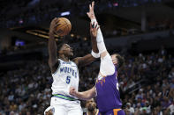 Minnesota Timberwolves guard Anthony Edwards (5) shoots as Phoenix Suns center Jusuf Nurkic defends during the first half of an NBA basketball game, Sunday, April 14, 2024, in Minneapolis. (AP Photo/Matt Krohn)