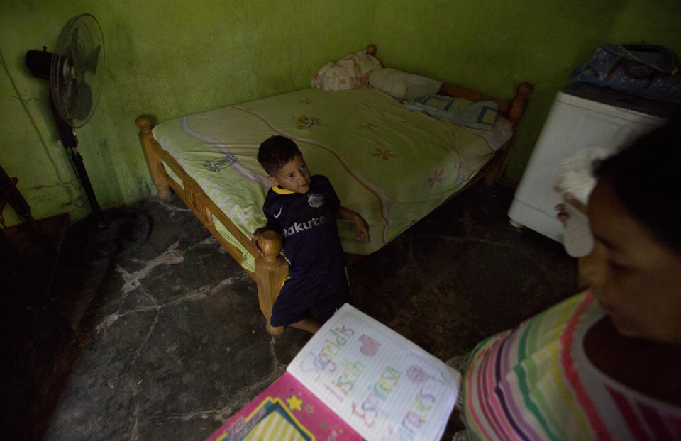 In this Dec. 10, 2018 photo, 3-year-old Elvis plays with his sister Solgreidy, 8, at their uncle's home in Punto Fijo , Venezuela. Their mother did not have the money to take them to Colombia with her, so she left them with her brother in the hopes of earning enough to feed them and, within time, reunite. (AP Photo/Fernando Llano)