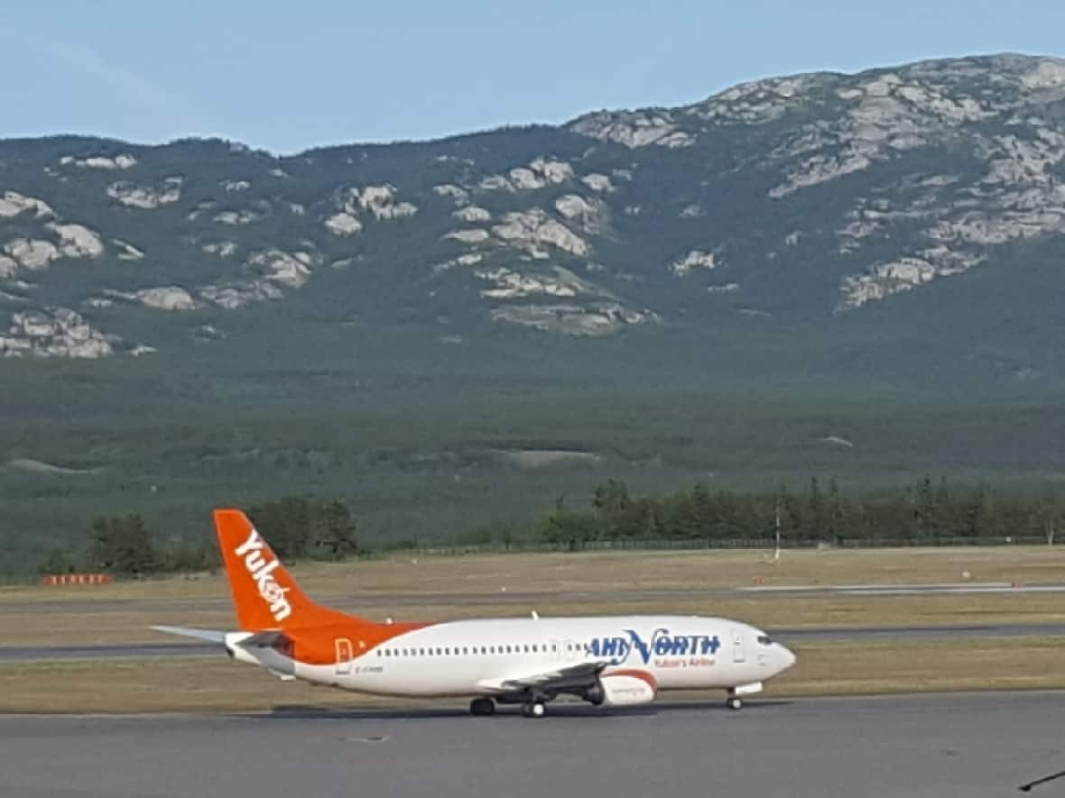 An Air North plane at the Whitehorse airport, summer 2021. The company announced it will operate a seasonal scheduled flight between May and September 2022 that will originate in Whitehorse, pick up passengers in Yellowknife and fly directly to Toronto. (Paul Tukker/CBC - image credit)