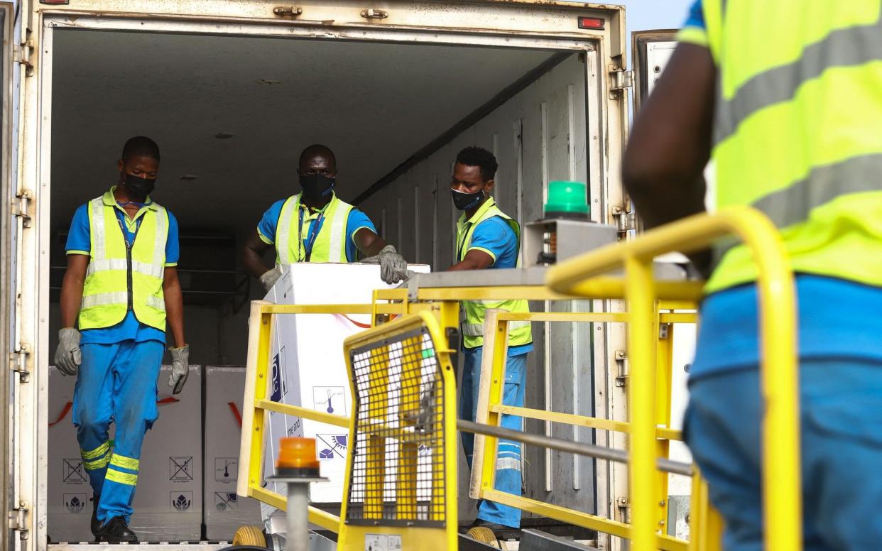 Airport workers unload a shipment of Covid-19 vaccines at Kotoka International Airport in Accra - Nipah Dennis/AFP