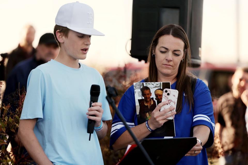 Kaizen Marsing reads an essay about his friend with his mom Lacey Marsing to a large group of people gathered on Wednesday in West Jordan at 9000 South and 1510 West where one year ago 13-year-old Eli Mitchell was killed by a drunk driver.