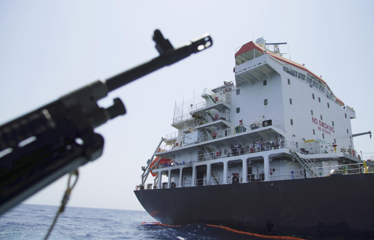 Sailors stand on deck above a hole the U.S. Navy says was made by a limpet mine on the damaged Panama-flagged, Japanese owned oil tanker Kokuka Courageous, anchored off Fujairah, United Arab Emirates, during a trip organized by the Navy for journalists, Wednesday, June 19, 2019. The limpet mines used to attack a Japanese-owned oil tanker near the Strait of Hormuz last week bore “a striking resemblance” to similar mines previously seen in Iran, a U.S. Navy explosives expert said Wednesday, stopping short of directly blaming Tehran for the assault. (AP Photo/Fay Abuelgasim)