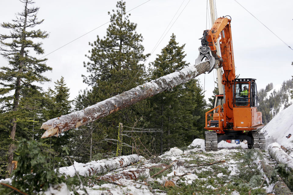 In this Feb. 22, 2017, photo, a log yarder moves a log into position above a slope where a crew is thinning a 100-acre patch on private land owned by the Nature Conservancy overlooking Cle Elum Lake, in Cle Elum, Wash. As part of a broader plan by the nonprofit environmental group to restore the pine forests of the Central Cascades so they are more resilient to wildfires and climate change, they're cutting down trees to save the forest. (AP Photo/Elaine Thompson)