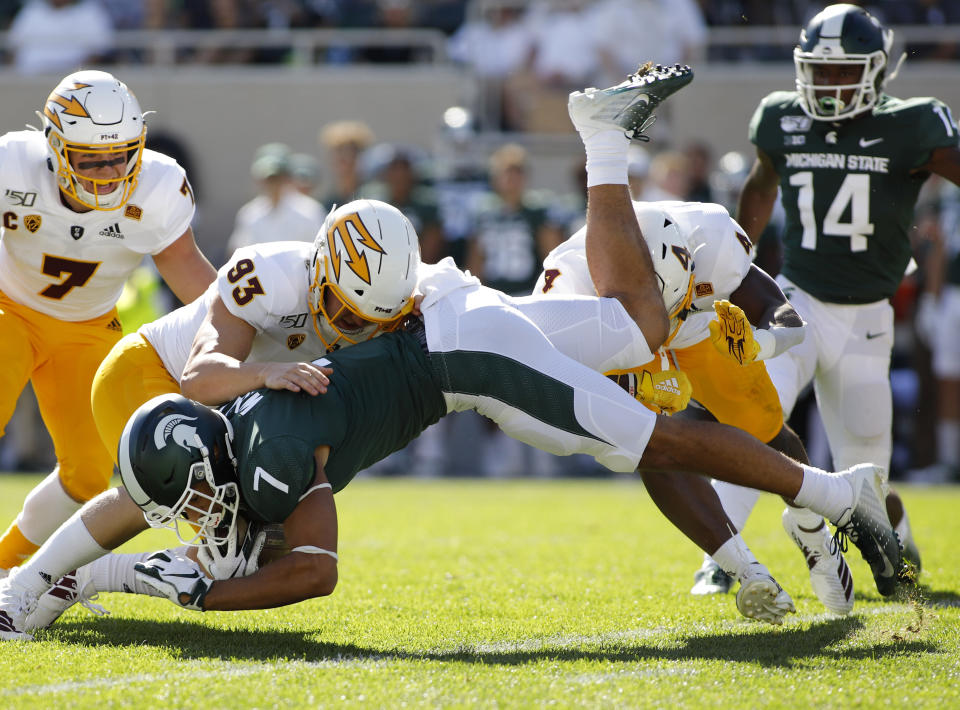 Michigan State's Cody White (7) is stopped by Arizona State's Erik Dickerson (93) and Evan Fields (4) during the first quarter of an NCAA college football game Saturday, Sept. 14, 2019, in East Lansing, Mich. (AP Photo/Al Goldis)