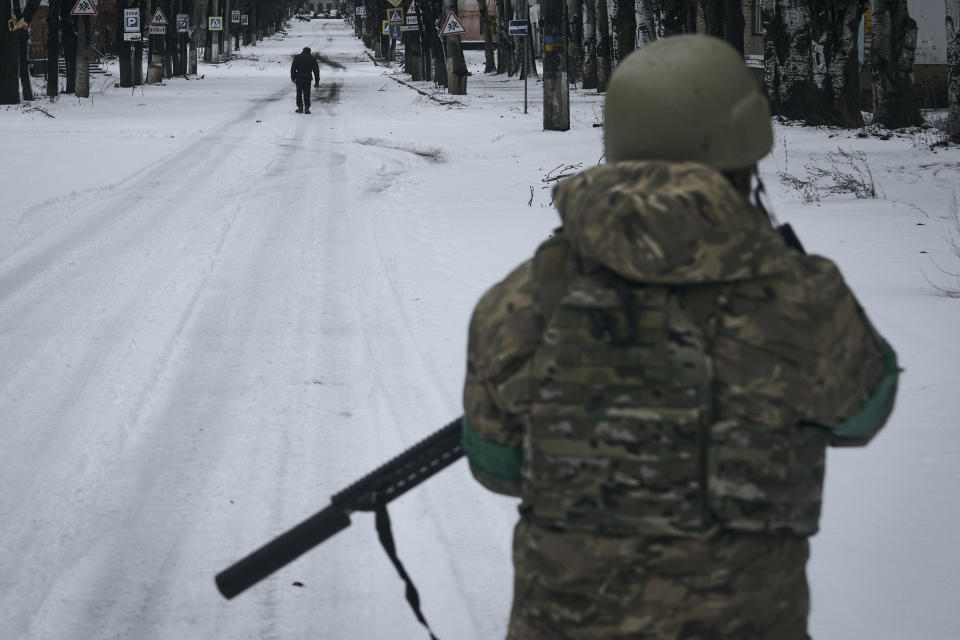 A Ukrainian soldier patrols the street in Bakhmut, Donetsk region, Ukraine, Tuesday, Feb. 14, 2023. (AP Photo/Libkos)