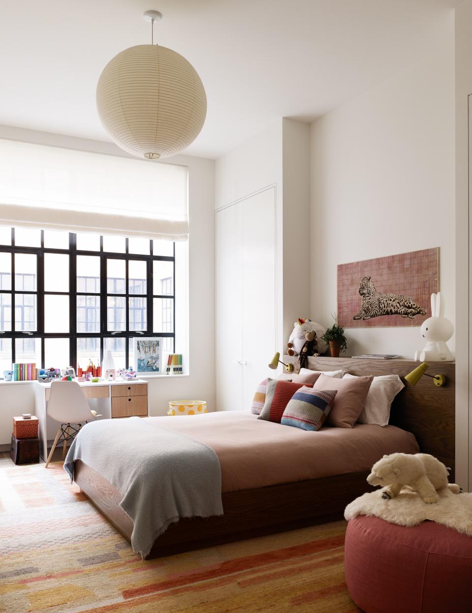 Santos’s daughter’s bedroom has an upholstered bed designed by Laura Santos Interiors and fabricated by Dune. The headboard is finished with wall sconces designed by Pierre Guariche in 1951, from Galerie Kreo. The desk is from Duc Duc and is paired with a  chair by Eames from Design Within Reach. The pendant light is by Isamu Noguchi and from The Noguchi Museum. The rug is from Woven Accents.