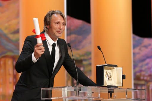 Danish actor Mads Mikkelsen celebrates on stage after being awarded with the Prix d'Interpretation Masculine (Best Actor) during the closing ceremony of the 65th Cannes film festival in Cannes