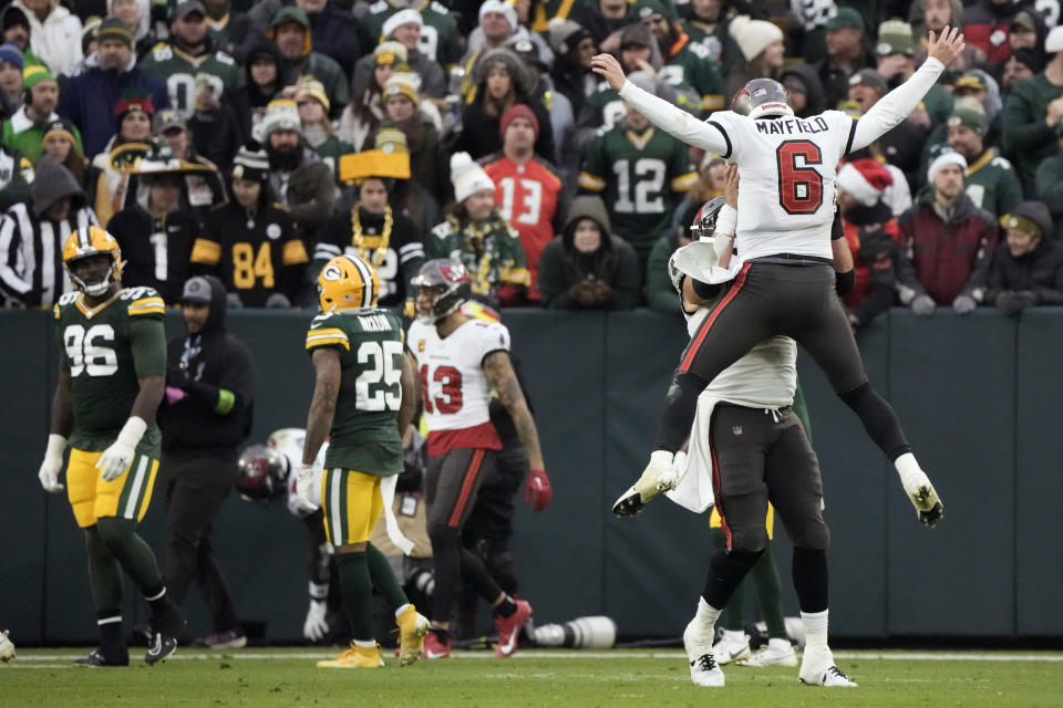 Tampa Bay Buccaneers quarterback Baker Mayfield (6) celebrates with teammate center Robert Hainsey after throwing a 52-yard touchdown pass during the second half of an NFL football game against the Green Bay Packers, Sunday, Dec. 17, 2023, in Green Bay, Wis. (AP Photo/Morry Gash)