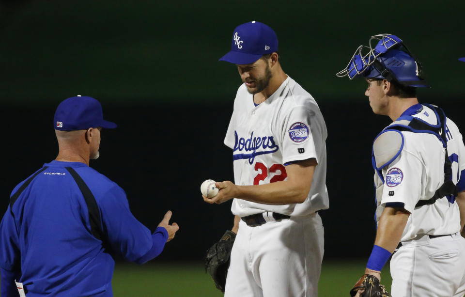 Los Angeles Dodgers' Clayton Kershaw (22), playing for the Oklahoma City Dodgers on a rehab assignment, hands the ball off to manager Travis Barbary as he is taken out of the Triple-A baseball game against the San Antonio Missions in the fifth inning Thursday, April 4, 2019, in Oklahoma City. Catcher Will Smith is at right. (AP Photo/Sue Ogrocki)