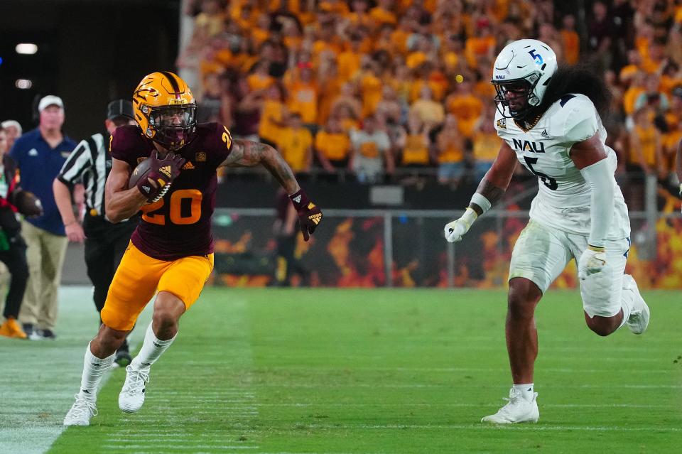 September 1, 2022; Tempe, Arizona; USA; ASU wide out Giovanni Sanders (20) steps out as he runs up the sidelines against NAU defensive lineman Nehemiah Magalei (6) during a game at Sun Devil Stadium.