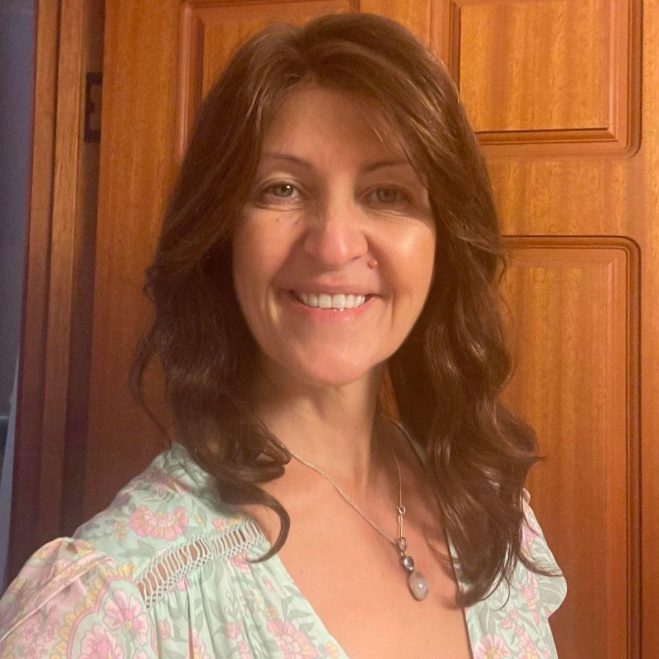 Alison Miles smiles in front of a door in her home.