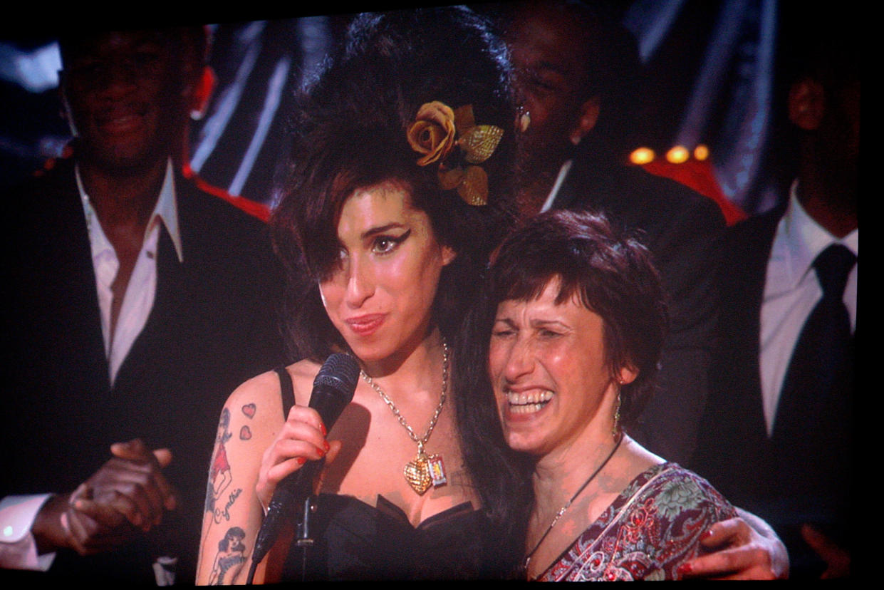 LOS ANGELES, CA - FEBRUARY 10:  (Via Broadcast from London) Singer Amy Winhouse (L) hugs her mother Janis Winehouse after hearing that she won Record of the Year award for 