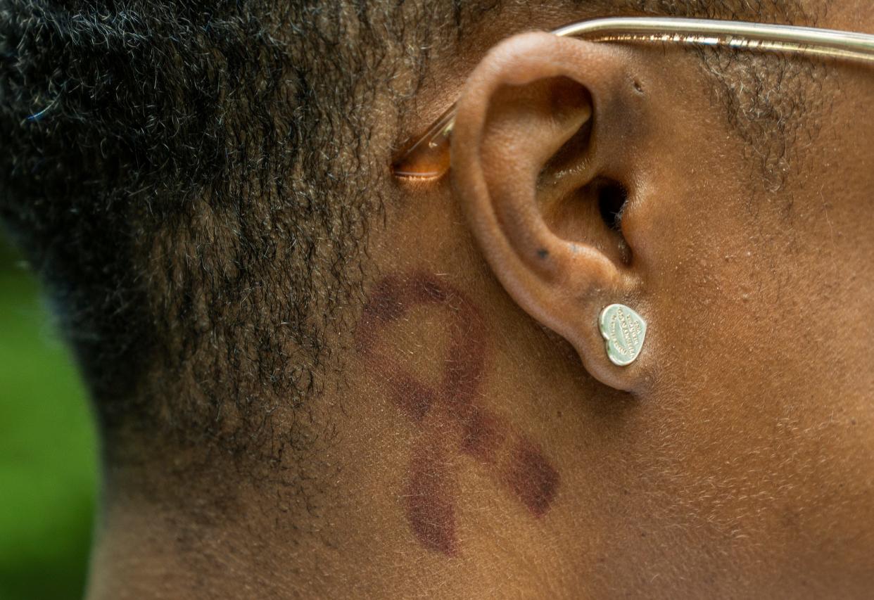 Markeeta Morrow has a breast cancer awareness ribbon tattoo behind her ear, seen on Friday, June 23, 2023, at Dillon Park in Noblesville.  