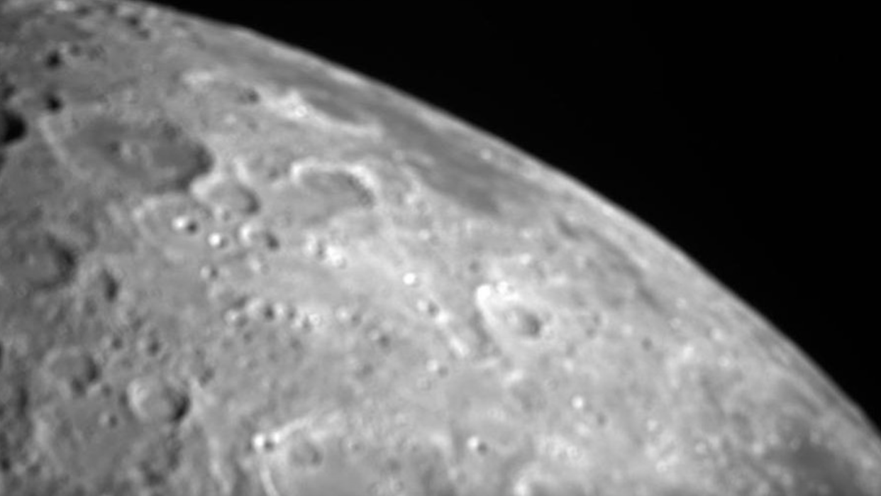  A close-up shot of the moon's north polar region, with many craters, against the blackness of space. 