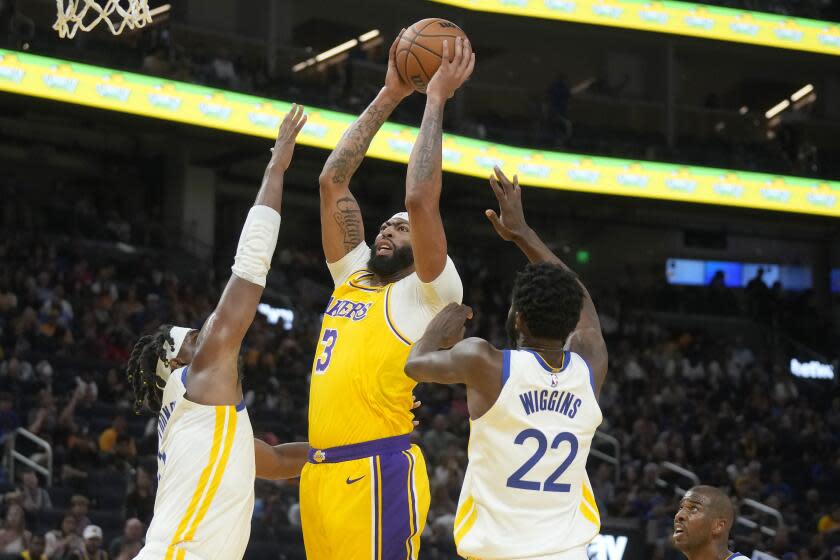 Los Angeles Lakers forward Anthony Davis (3) and Golden State Warriors forwards Kevin Looney (left) and Andrew Wiggins (22) shot.  (AP Photo/Jeff Qiu)
