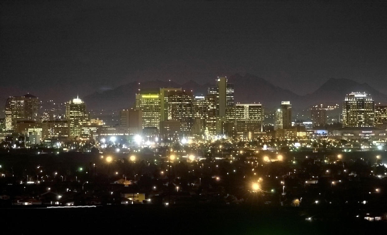 FILE - The Squaw Peak Mountains are seen behind the illuminated Phoenix skyline on February 28, 2002, from South Mountain in Phoenix. Eight of the 10 largest cities in the U.S. lost population during the first year of the pandemic, with only Phoenix and San Antonio gaining new residents from 2020 to 2021, according to new estimates released, Thursday, May 26, 2022, by the U.S. Census Bureau. (AP Photo/Mel Evans, File)